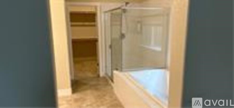A hallway with a glass door leading to a bedroom.