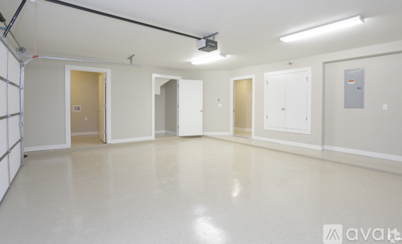 A spacious room with white walls and a grey floor.