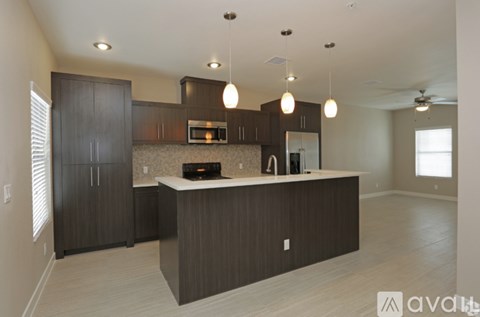 A modern kitchen with dark wood cabinets and a central island.