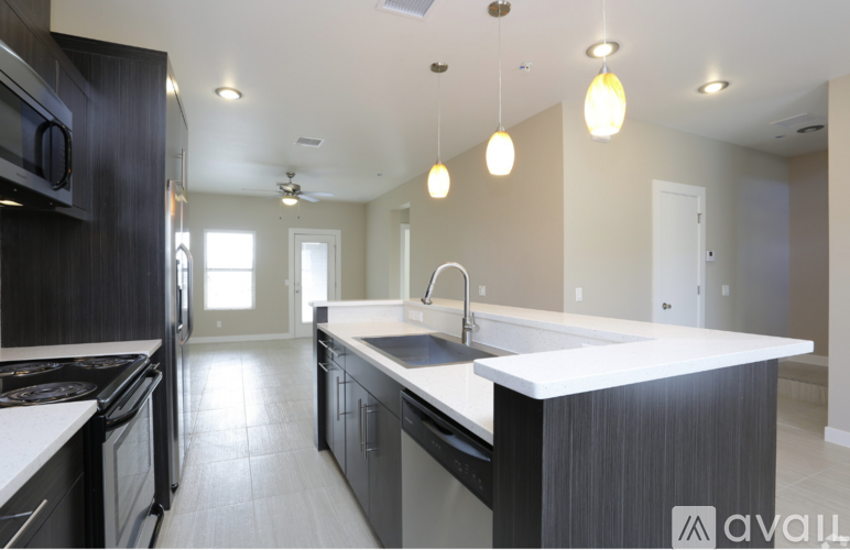 A modern kitchen with a large island and stainless steel appliances.