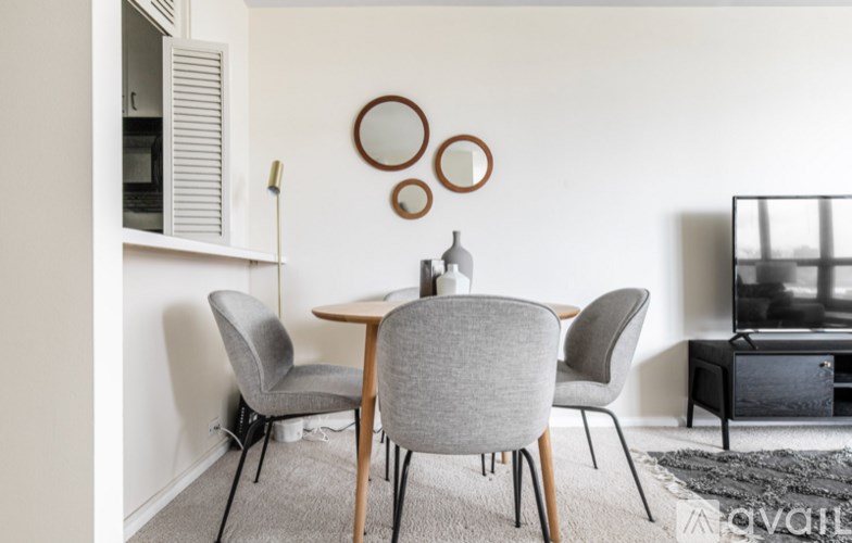 A modern dining room with a grey table and chairs.
