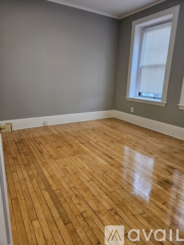 A room with a bed, chair, and a radiator.