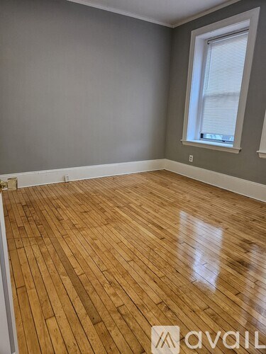 A room with a bed, chair, and a radiator.