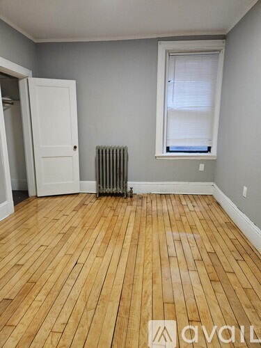 A bedroom with a bed, a window with curtains, a dresser with a mirror, and a rug on the floor.