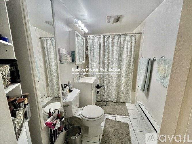A bathroom with a toilet, sink, and shower area.