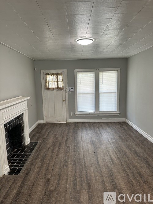 A room with a fireplace and wood flooring.