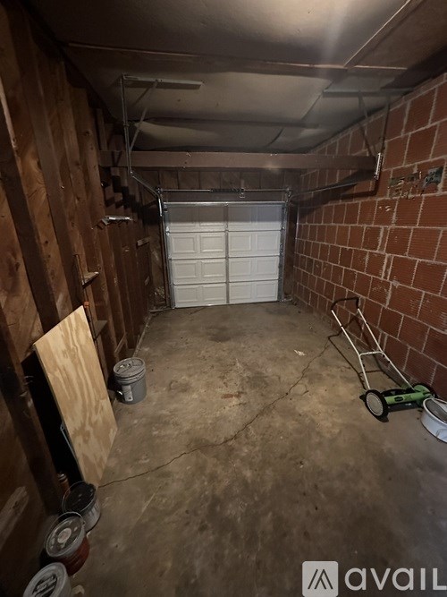 A garage with a white door and a brick wall.