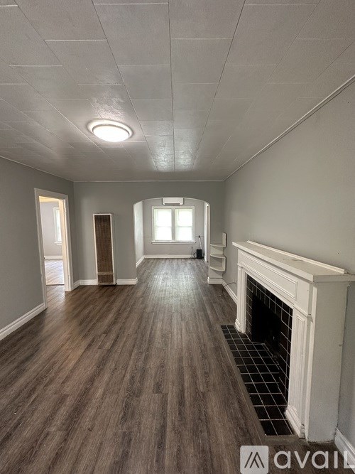 A room with wooden floors and a fireplace.