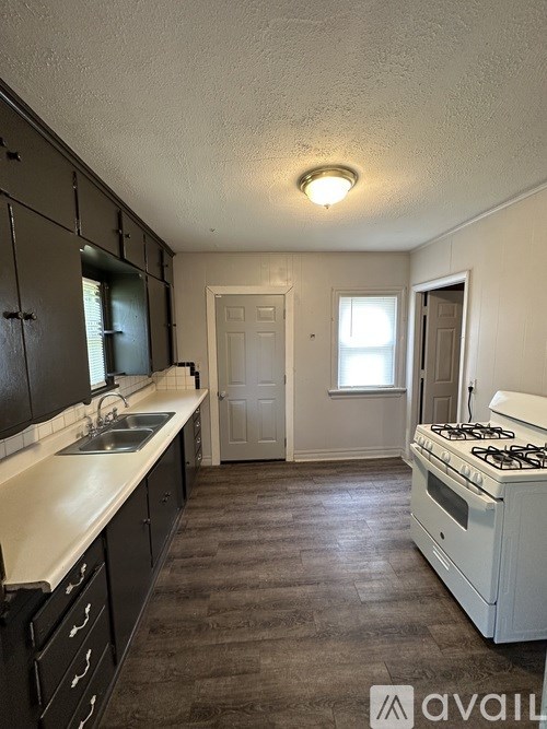 A kitchen with a white counter top and a white stove.