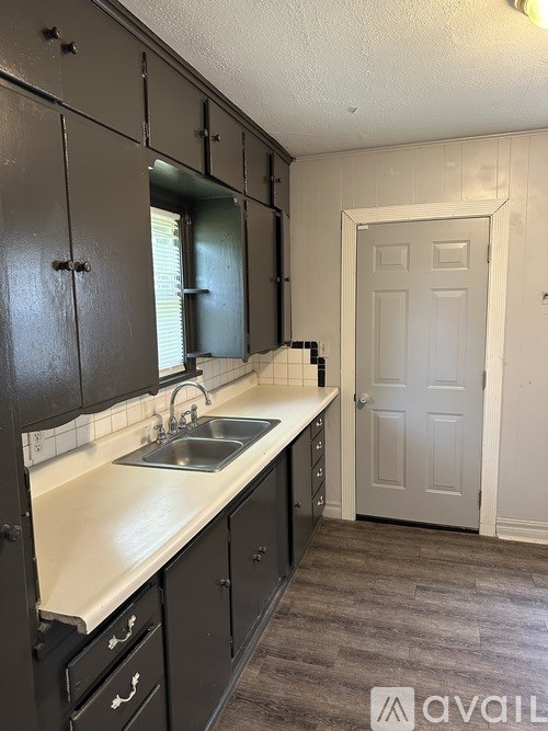 A kitchen with black cabinets and a white countertop.