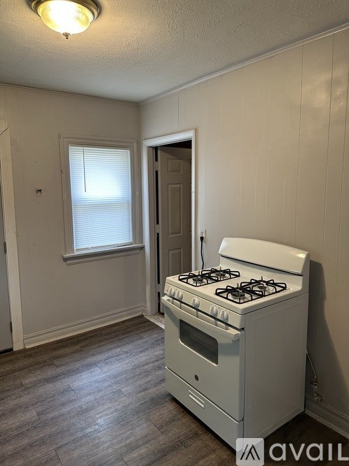 A white gas stove in a room with a window.