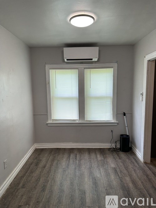 A room with a window and a wall-mounted air conditioner.