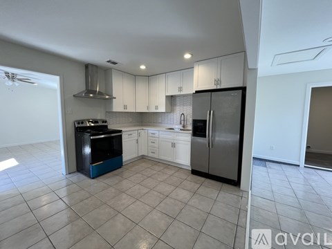 A kitchen with white cabinets and a black dishwasher.