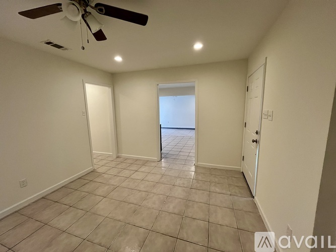 A room with a ceiling fan and tiled flooring.
