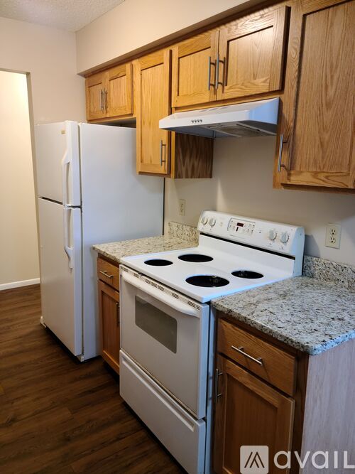 A kitchen with a white stove top oven and a white refrigerator.