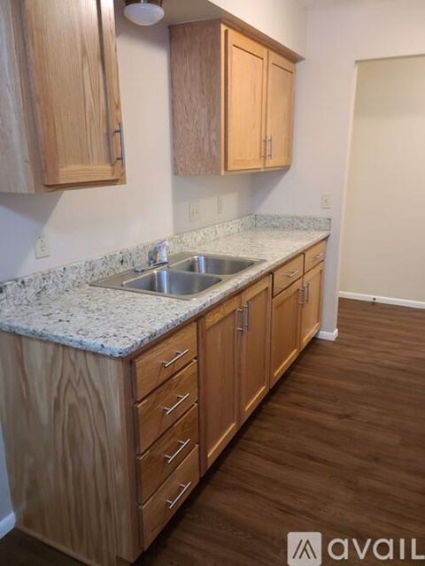 A kitchen with wooden cabinets and a granite countertop.