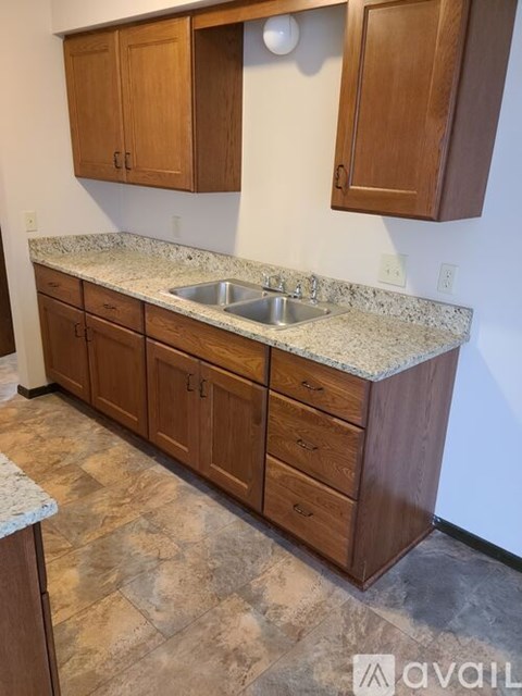 A kitchen with wooden cabinets and a granite countertop.