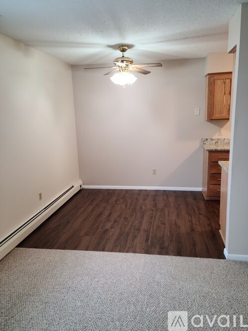 A room with a ceiling fan and wooden flooring.