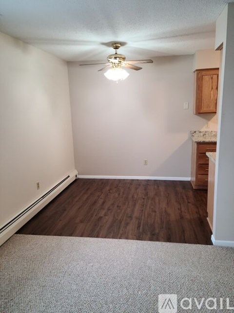 A room with a ceiling fan and wooden flooring.