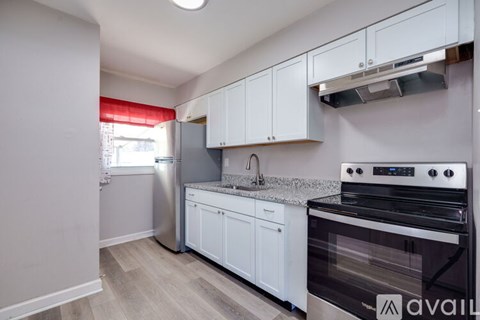 A kitchen with white cabinets and a black stove top oven.