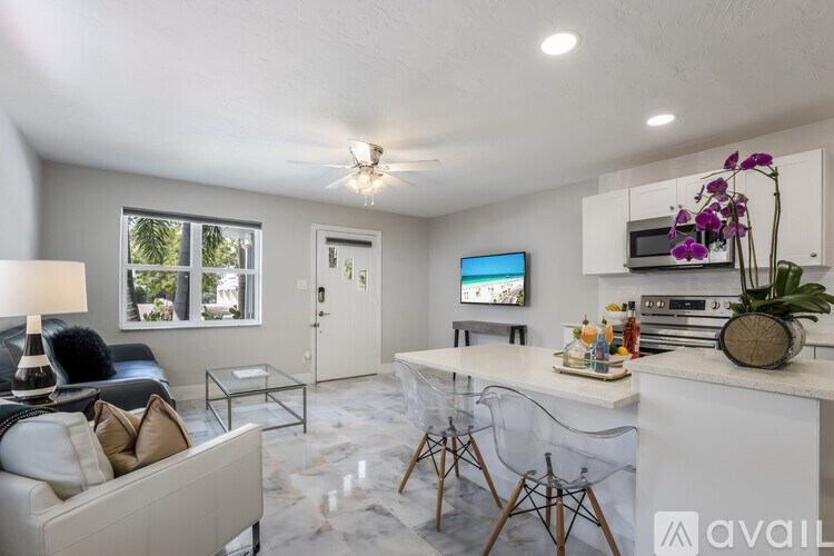 A living room with a white couch and a television on the wall.