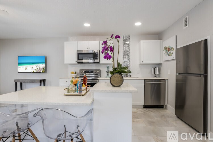A kitchen with a white countertop and a black refrigerator.
