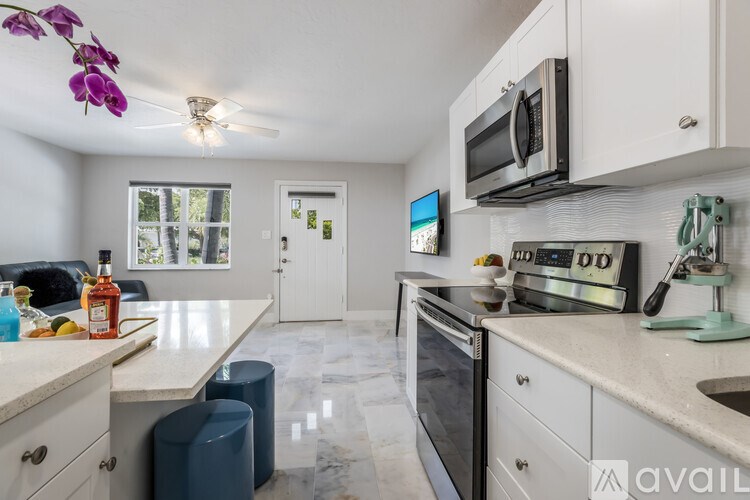 A kitchen with a white counter top and a black microwave.