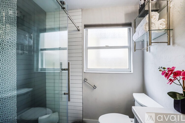 A bathroom with a toilet, sink, and shower.