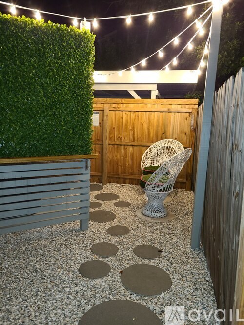 A backyard with a white chair and a wooden fence.