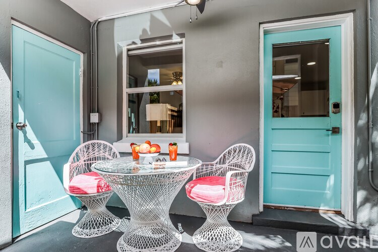 A table with two chairs and a bowl of fruit on it.
