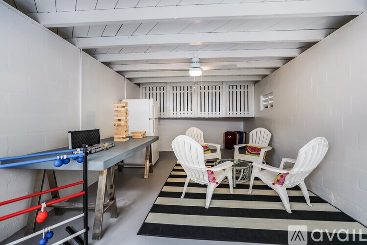 A room with a foosball table, chairs, and a rug.