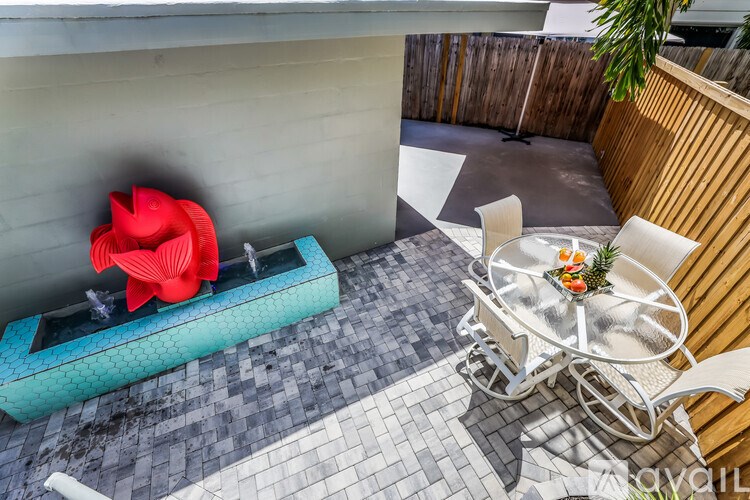 A red flower is in a blue vase on a table.