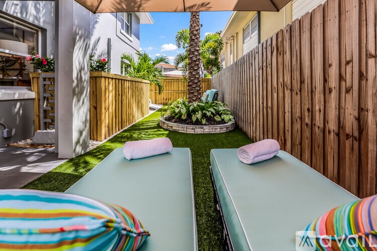 A patio with a table and chairs is surrounded by a wooden fence.