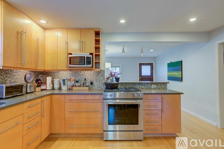 A kitchen with wooden cabinets and a stainless steel oven.