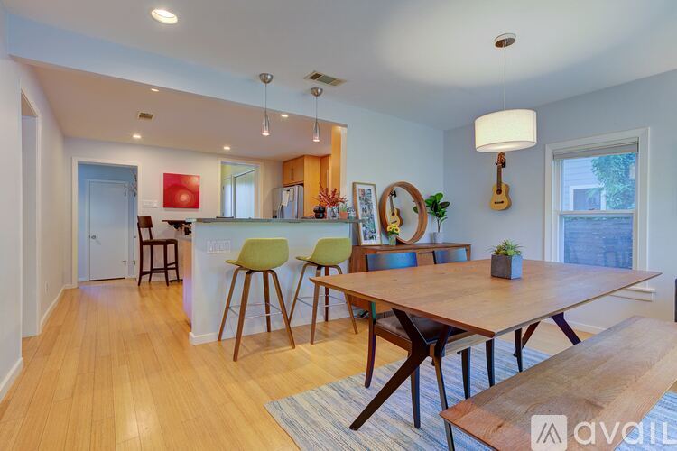 A modern dining room with a wooden table and chairs.