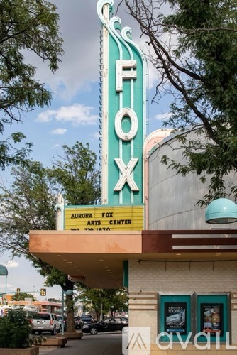 A green and white sign that says "FOX" on top of a building.