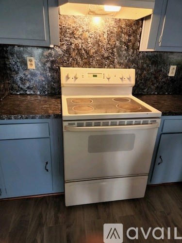 A white oven with a stove top sits in a kitchen.