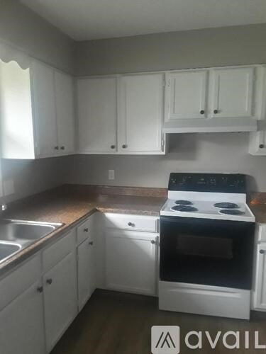 A kitchen with white cabinets and a black stove top oven.