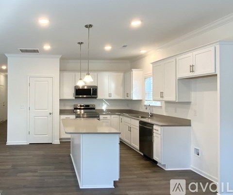 A modern kitchen with white cabinets and a central island.