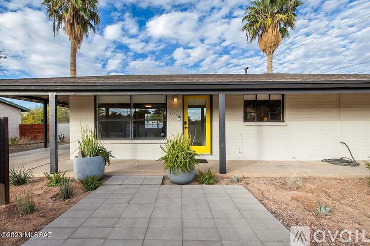 A house with a yellow door and a tiled walkway in front.