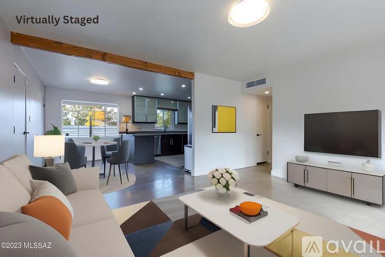 A modern living room with a white sofa, a coffee table, and a television.
