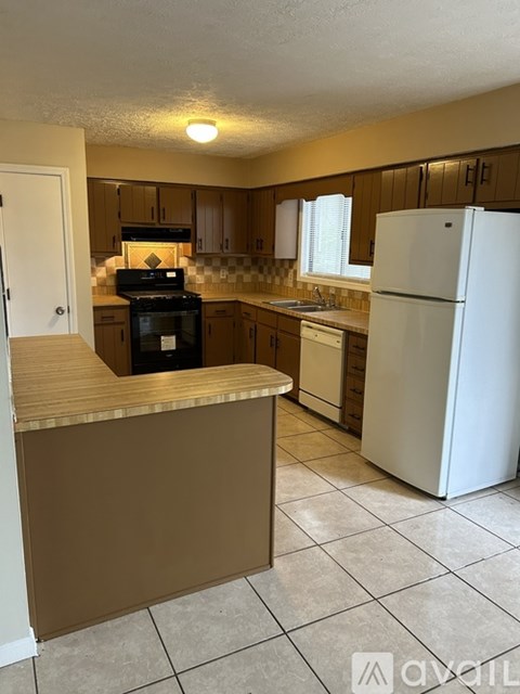 A kitchen with a white refrigerator and a brown counter.