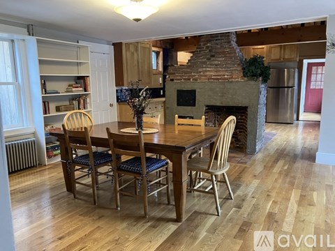 A dining room with a wooden table and chairs.
