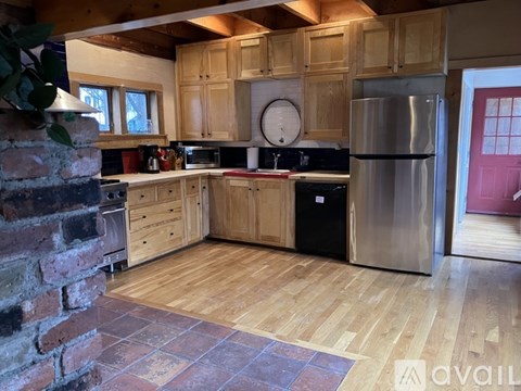 A kitchen with wooden cabinets and a brick wall.