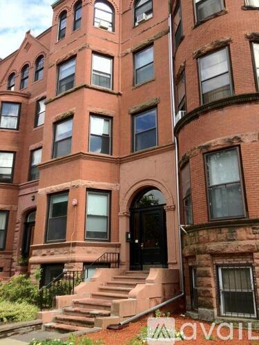 A red brick building with a black door and windows.