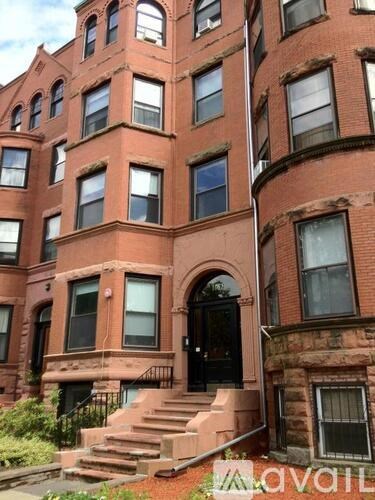 A red brick building with a black door and windows.