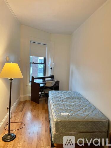 A bedroom with a bed, desk, and chair.