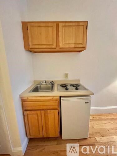 A kitchen with wooden cabinets and a white dishwasher.