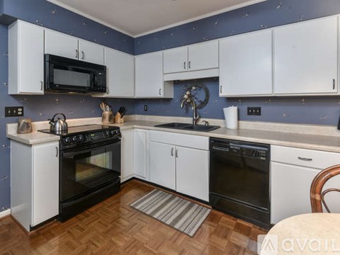 A kitchen with white cabinets and a wooden floor.
