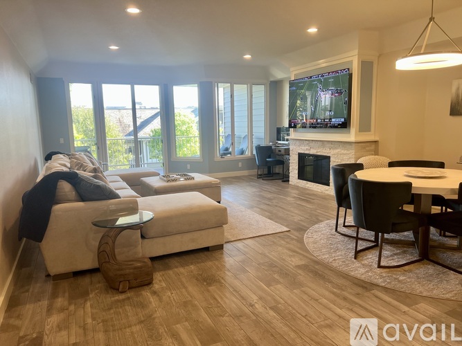 A living room with a couch, a coffee table, a TV, and a fireplace.